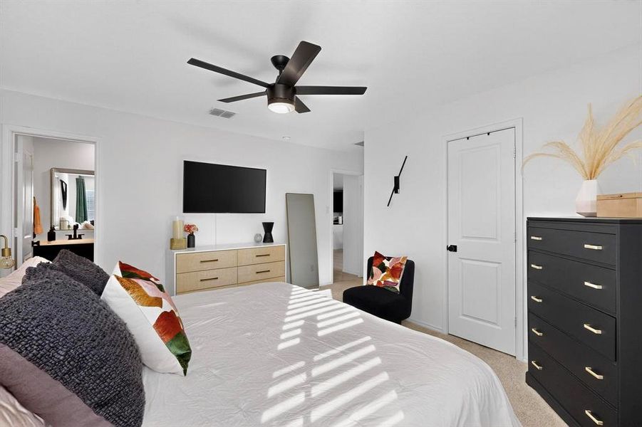 Bedroom with light carpet and a ceiling fan Bedroom with light carpet and a ceiling fan