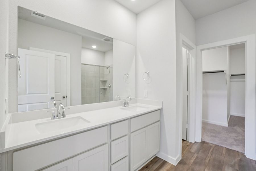 A bathroom with white cabinets.