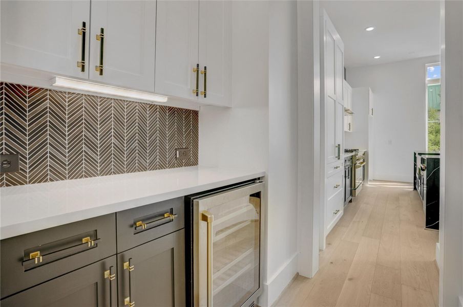 The butler's pantry sits between the dining area and kitchen and includes a wine fridge and additional storage space. The butler's pantry sits between the dining area and kitchen and includes a wine fridge and additional storage space.