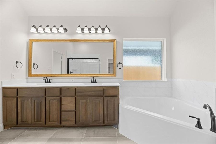 Full bathroom with a bath, double vanity, light tile patterned flooring, and a stall shower Full bathroom with a bath, double vanity, light tile patterned flooring, and a stall shower