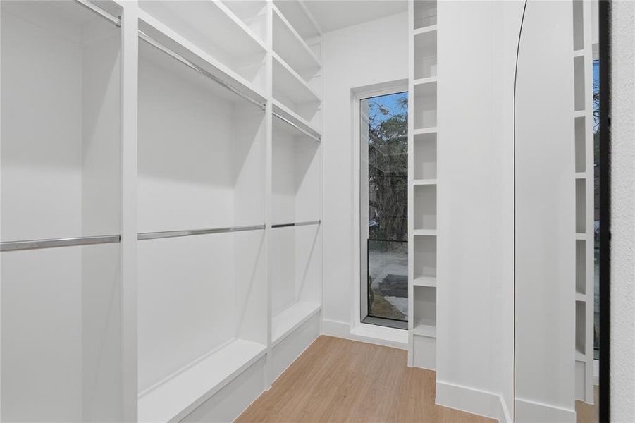 Walk in closet with light wood-type flooring