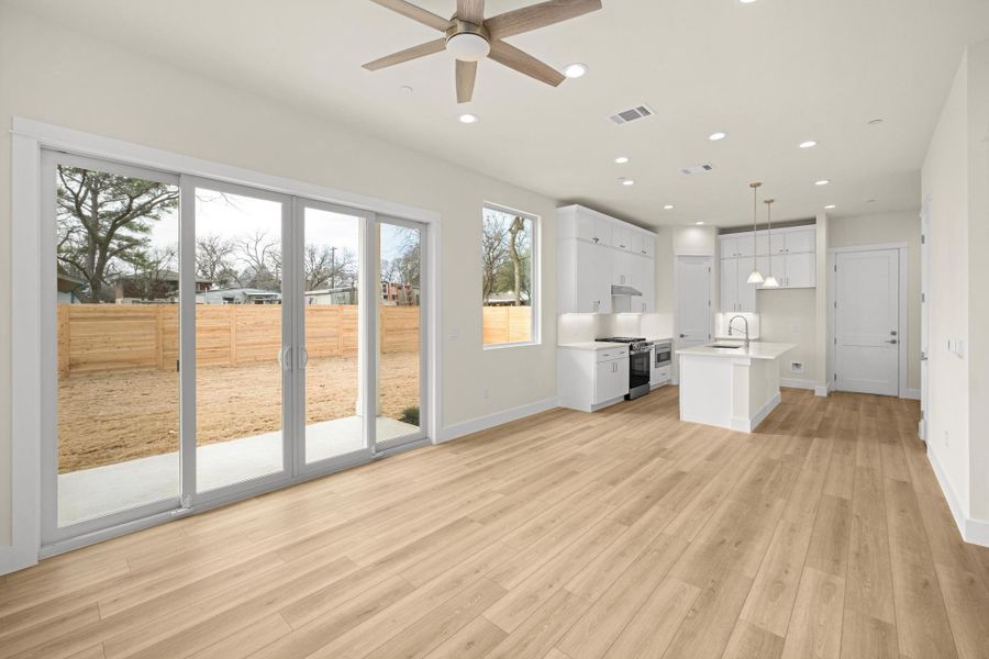 Open  floorpan, sliding doors, high ceilings, and a neutral color palette throughout.