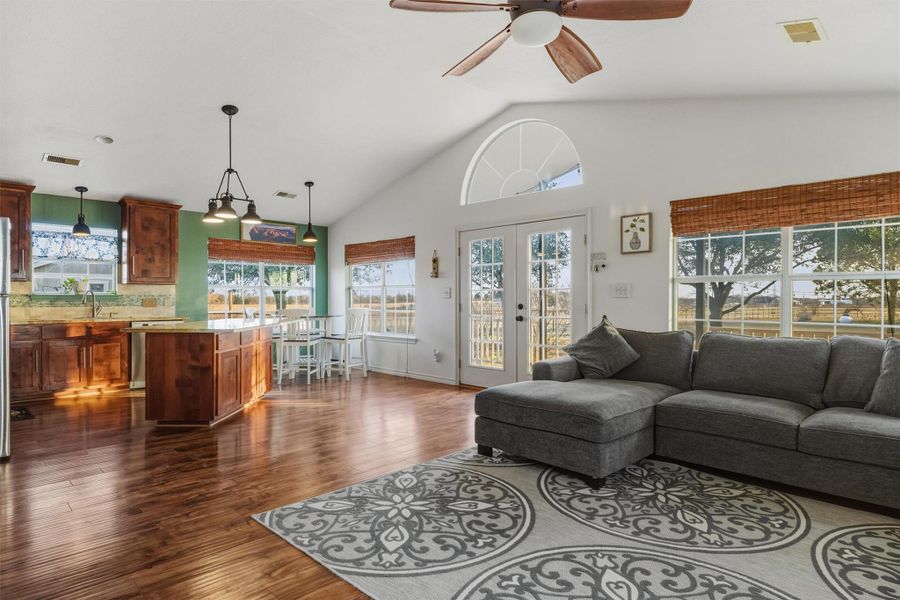 guest house Living room featuring dark wood finished floors, a high ceiling, french doors, and ceiling fan