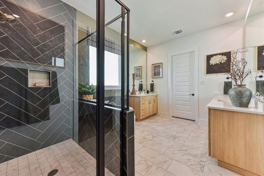 Herringbone wall tile and stone-look flooring anchor this spacious master bath layout.