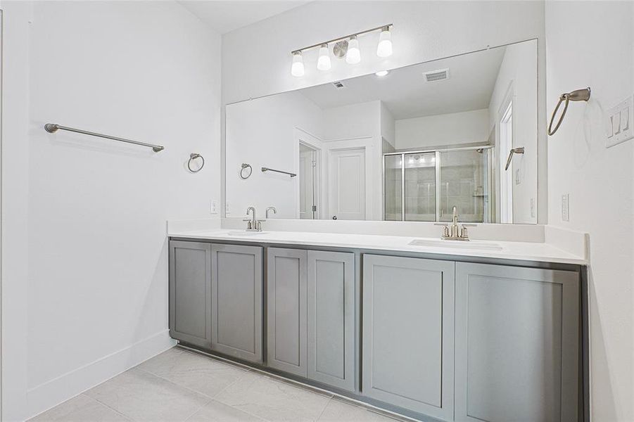 Full bath with a shower stall and double vanity