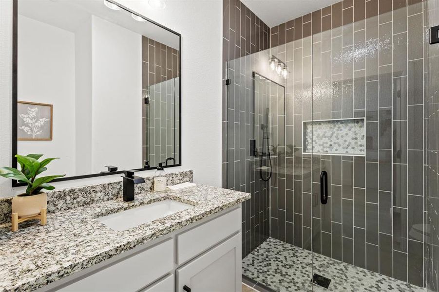 Bathroom featuring a stall shower and vanity