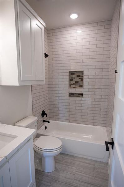 Bathroom with vanity, bathing tub / shower combination, light wood-style floors, and recessed lighting Bathroom with vanity, bathing tub / shower combination, light wood-style floors, and recessed lighting