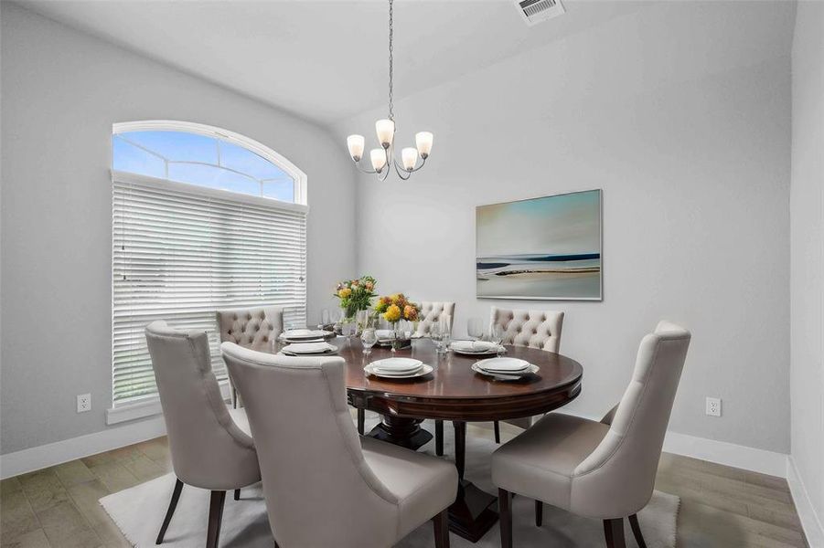 Make memories gathered around the table with your family and friends! This dining room features high ceilings, large windows, wood look tile and a beautiful chandelier.