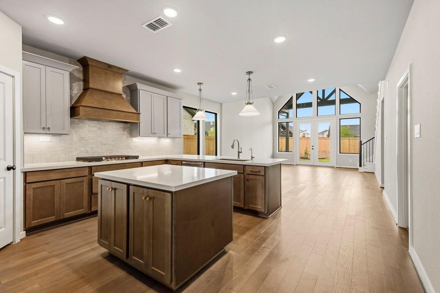 Check out this incredible kitchen featuring opulent finishes, complete with a chef's style kitchen island in the center. An impeccable wooden venthood adds the perfect designer touch. Check out this incredible kitchen featuring opulent finishes, complete with a chef's style kitchen island in the center. An impeccable wooden venthood adds the perfect designer touch.