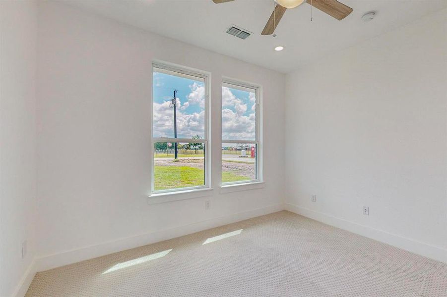 Empty room featuring ceiling fan and carpet floors