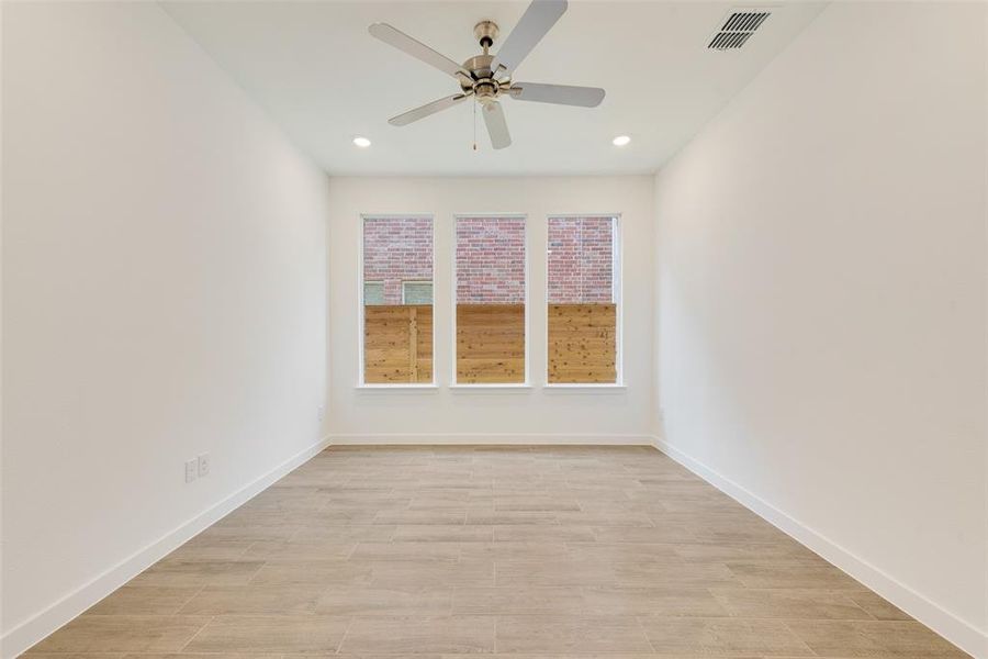 Unfurnished room with ceiling fan and light hardwood / wood-style flooring