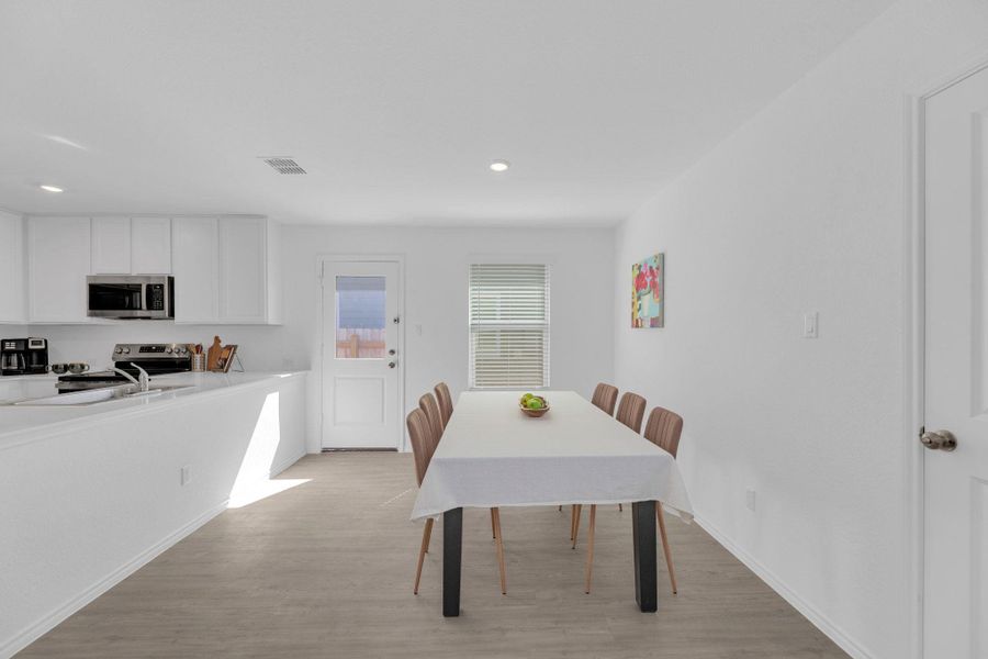 Dining area with light vinyl floors and recessed lighting
