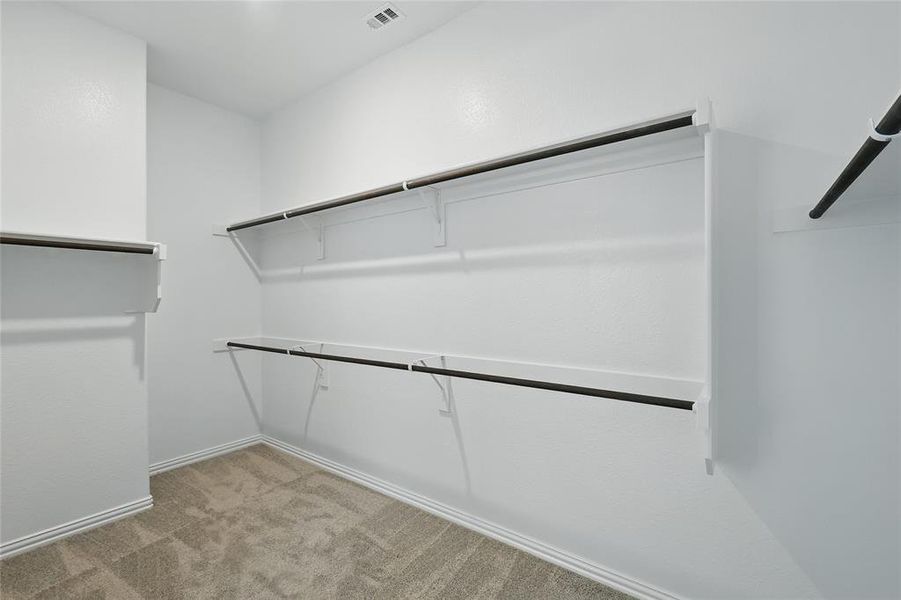 Walk in closet featuring light colored carpet Walk in closet featuring light colored carpet