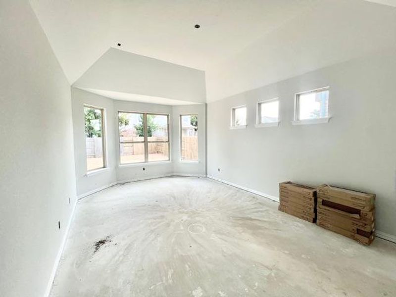 Empty room with lofted ceiling and concrete flooring Empty room with lofted ceiling and concrete flooring