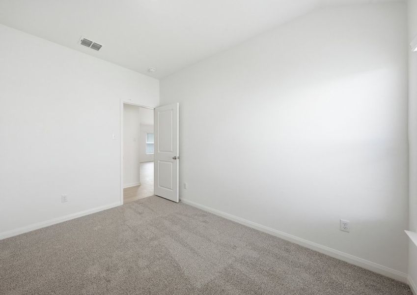 Secondary bedroom featuring carpet flooring and a closet doorway. Secondary bedroom featuring carpet flooring and a closet doorway.