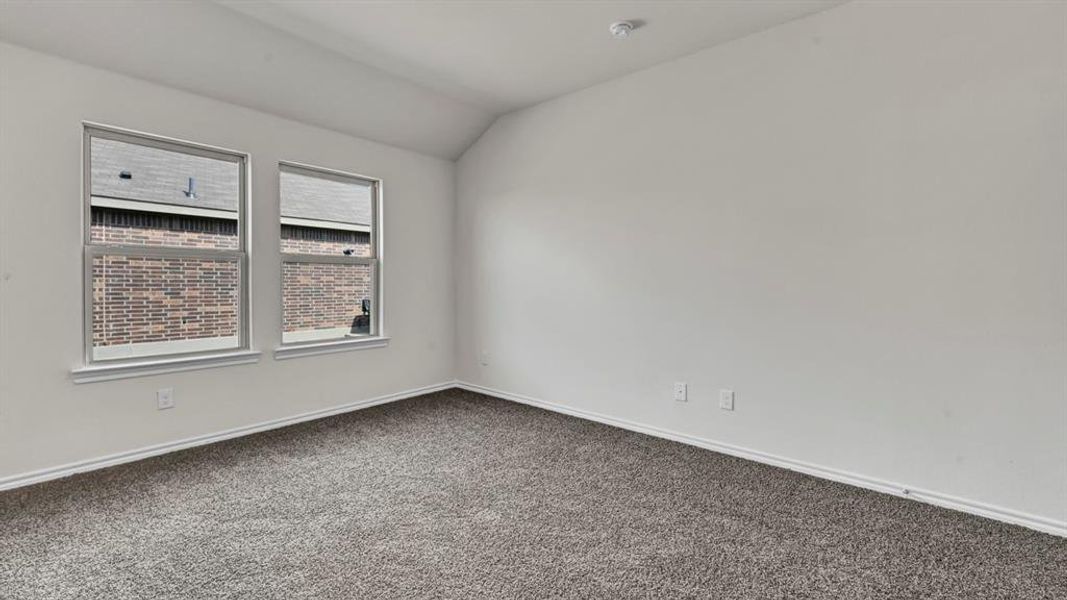 Carpeted room featuring two windows with white trim, white walls, and a sloped ceiling