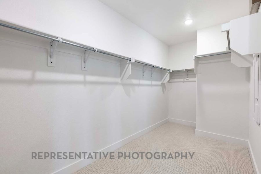 Spacious closet with light colored carpet Spacious closet with light colored carpet