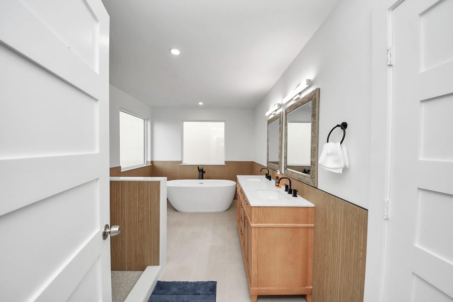 Primary bath with a minimalism style is characterized by simplicity, clean lines, and lots of light. The door on the right opens to the private water closet. Primary bath with a minimalism style is characterized by simplicity, clean lines, and lots of light. The door on the right opens to the private water closet.