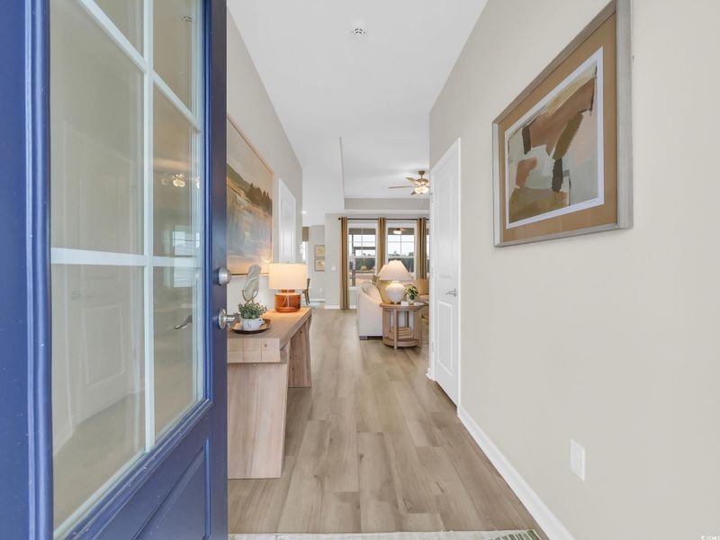 Corridor featuring light wood-style flooring and baseboards Corridor featuring light wood-style flooring and baseboards