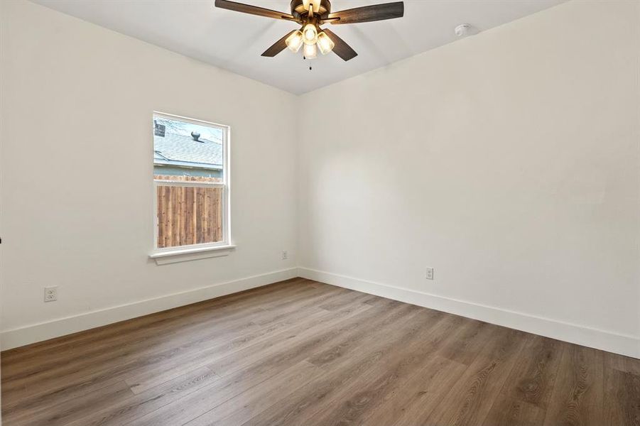 Spare room featuring wood finished floors, baseboards, and ceiling fan