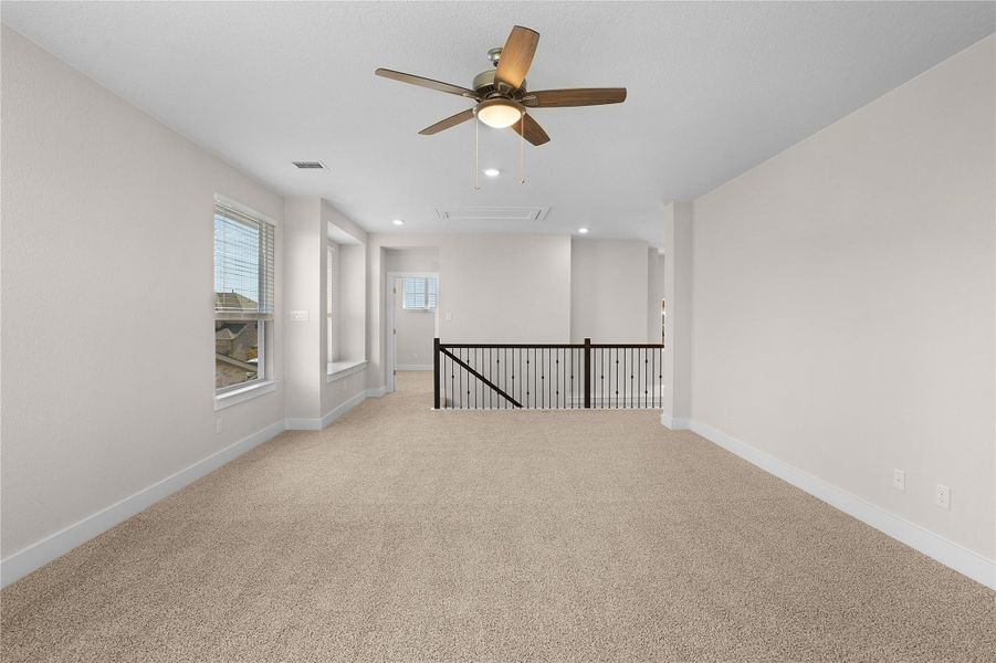 Unfurnished room featuring attic access, ceiling fan, light carpet, recessed lighting, and baseboards
