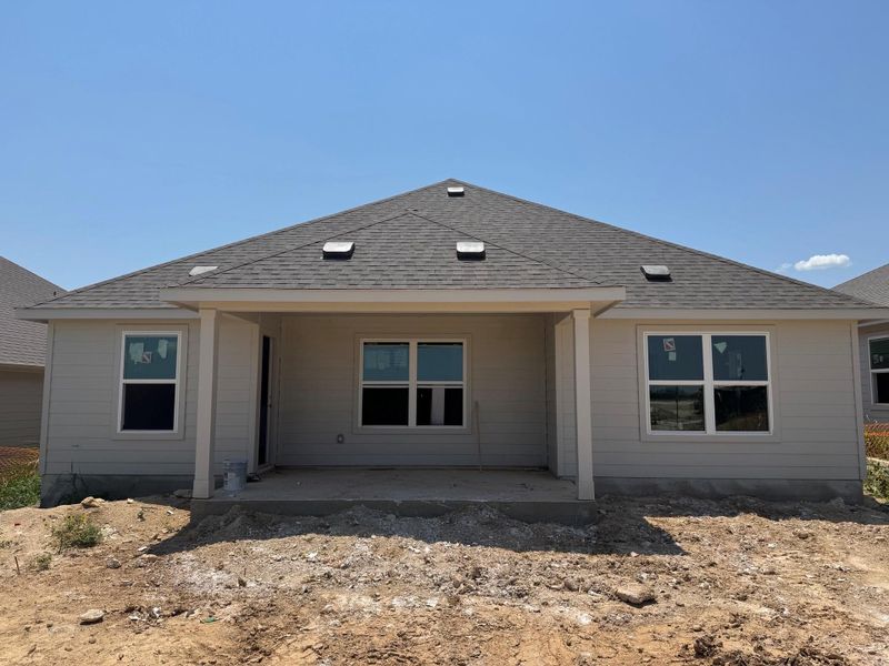 Rear view of property featuring a patio and roof with shingles