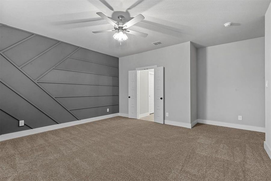 Unfurnished bedroom featuring ceiling fan and carpet