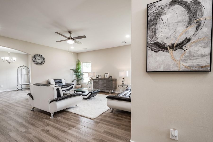 Spacious living area with neutral tones and modern ceiling fan Spacious living area with neutral tones and modern ceiling fan