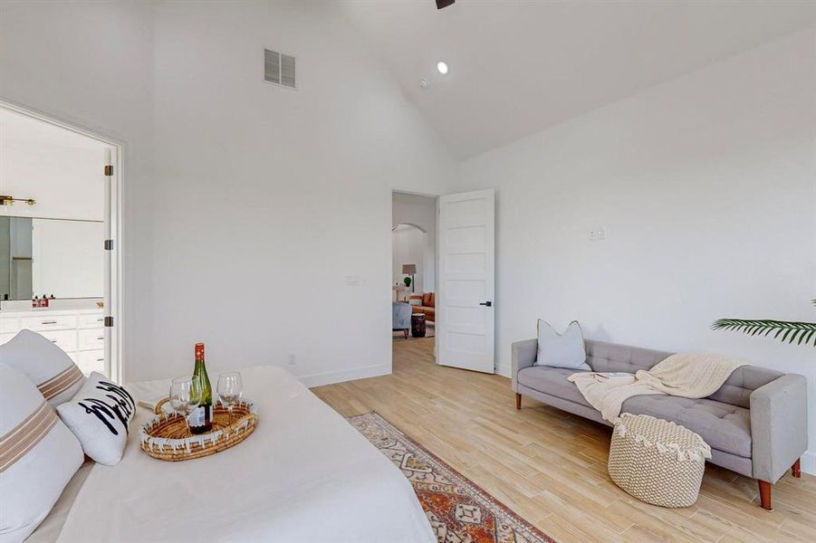 Main Bedroom with light hardwood / wood-style flooring and high vaulted ceiling