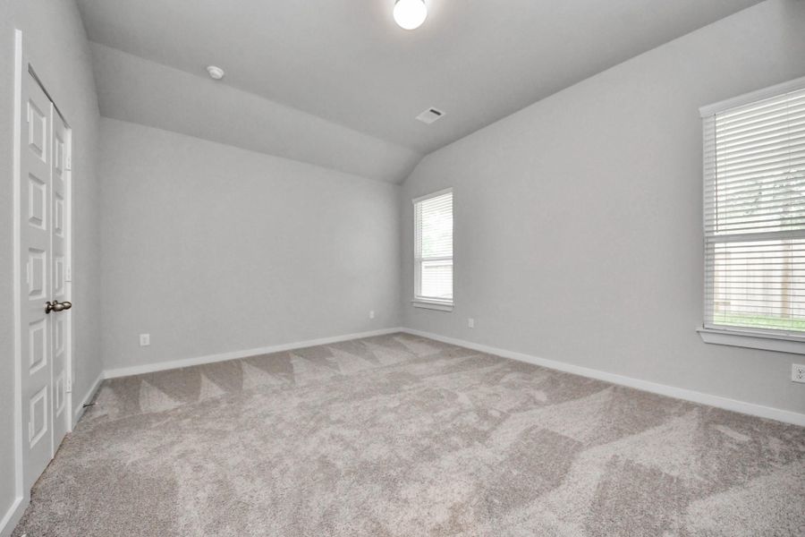Escape to tranquility in this spacious primary room, adorned with plush carpeting and bathed in the soothing hues of warm paint colors, creating a cozy retreat for relaxation. Sample photo of completed home with similar floor plan. Actual colors and selections may vary.