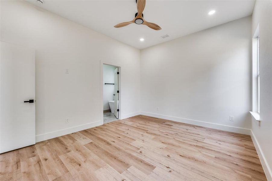 Spare room featuring light wood-style flooring, ceiling fan, and recessed lighting