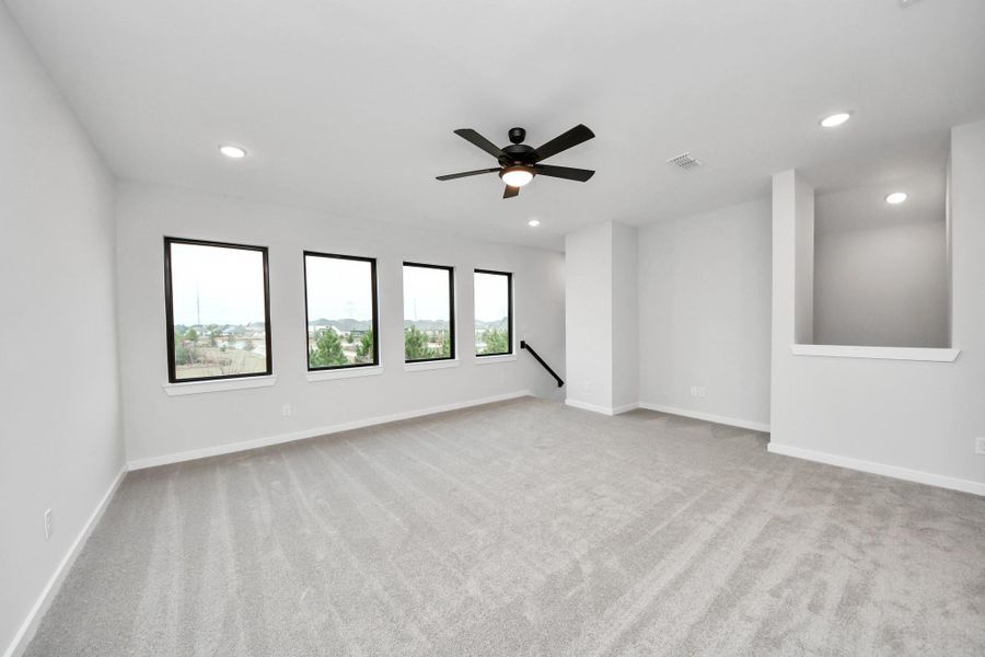 Oversized Game room. Behind us is the large room overlooking the main stairway and in front of us are a second set of stairs down to the kitchen.