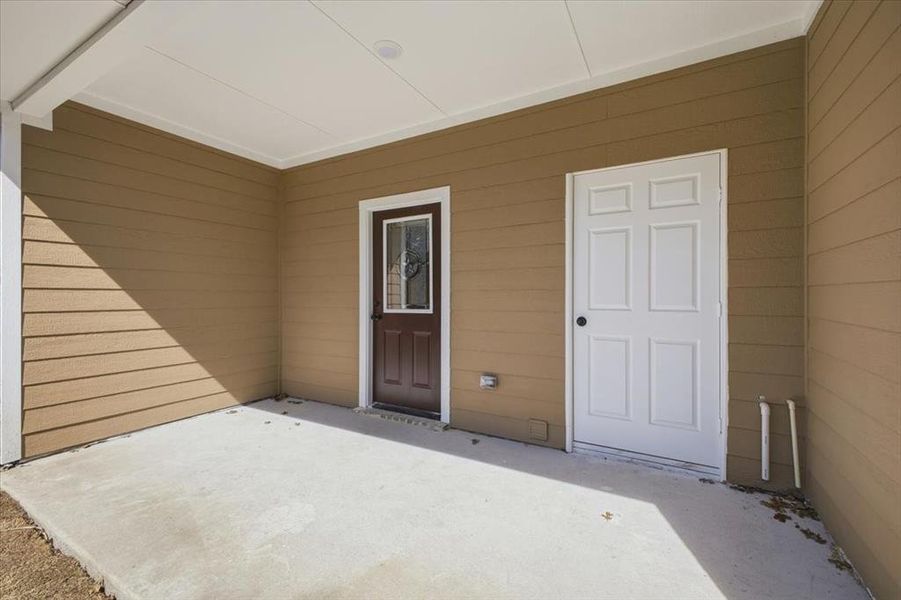 View of exterior entry with a patio area