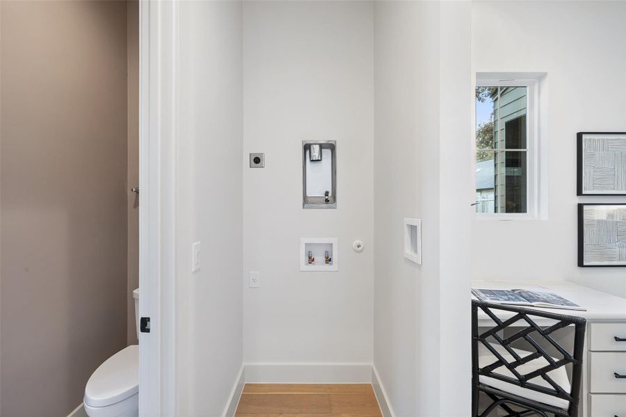 Laundry area featuring hookup for an electric dryer, hardwood / wood-style flooring, and hookup for a washing machine