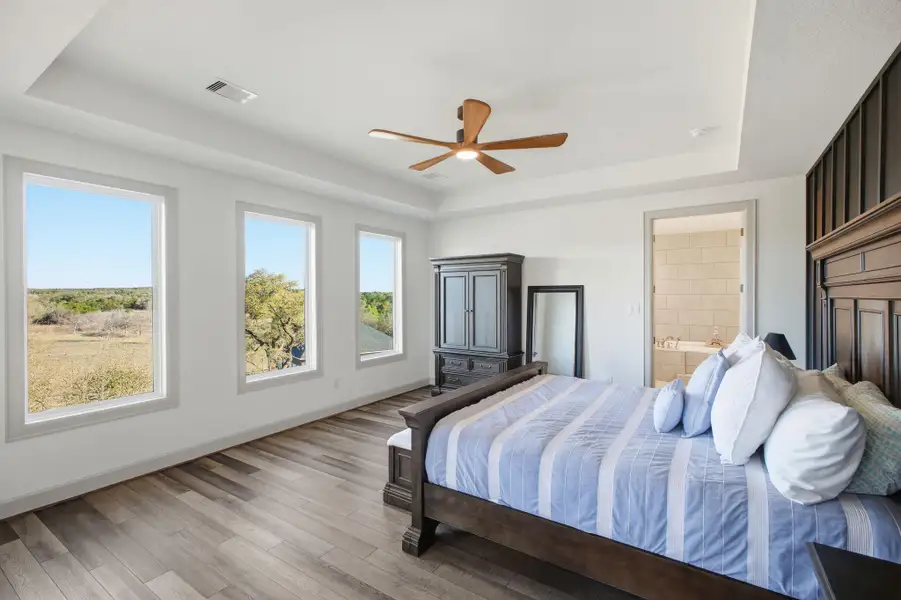 This inviting room features wood-look flooring and three large windows providing views of the surrounding landscape
