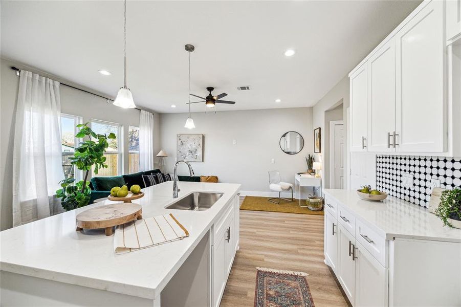 Sleek and modern, the kitchen features a large island, elegant backsplash, and recessed lighting for a fresh, contemporary feel.