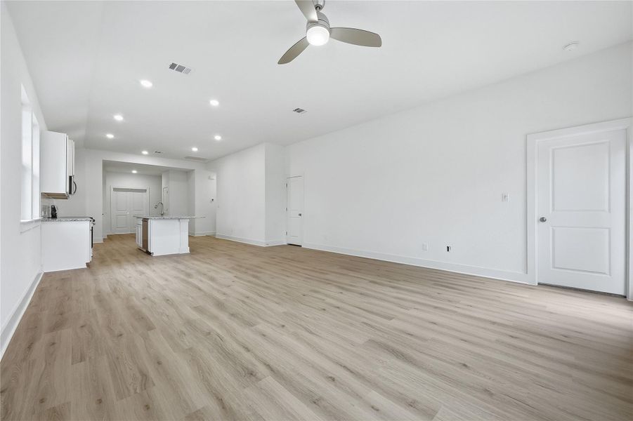 Unfurnished living room with light wood finished floors, ceiling fan, and recessed lighting