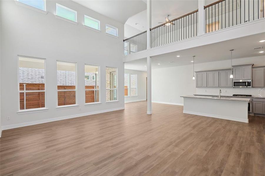 Unfurnished living room featuring dark wood finished floors, a high ceiling, and a ceiling fan Unfurnished living room featuring dark wood finished floors, a high ceiling, and a ceiling fan