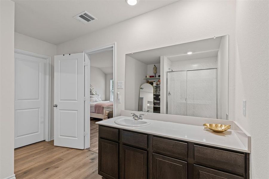 Primary suite bath with a shower stall, vanity, light wood finished floors, and recessed lighting and tons of storage. Primary suite bath with a shower stall, vanity, light wood finished floors, and recessed lighting and tons of storage.