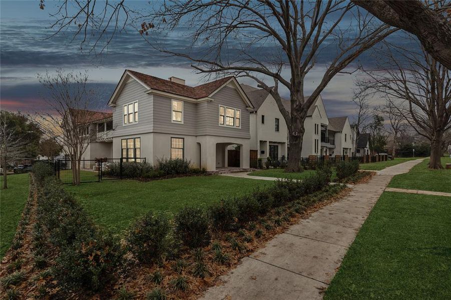 View of front of home featuring a front yard, fence, and stucco siding