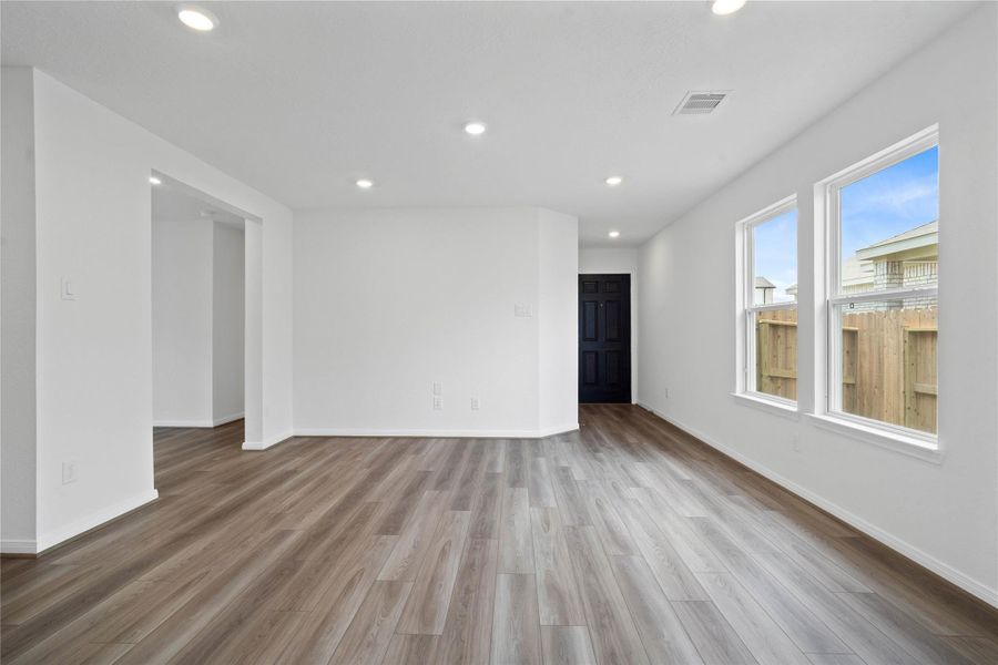 Bring family and friends together in this beautiful family room! It features soaring ceilings, recessed lighting, custom paint, stunning VP flooring, and large windows - which will fill the space with natural light all day long.