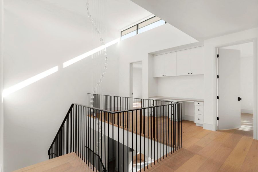 Hallway with light wood-type flooring and a high ceiling