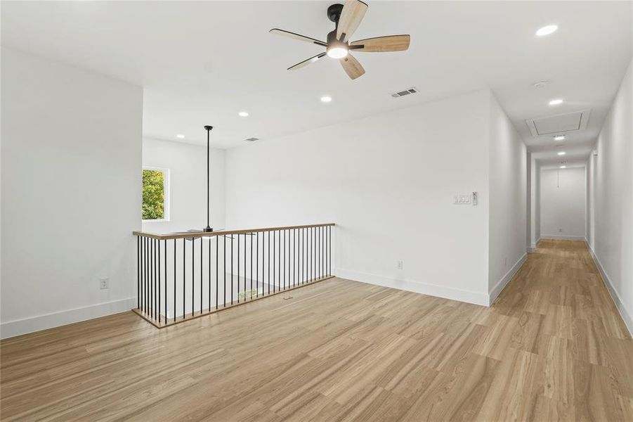 Empty room featuring ceiling fan, light wood-style flooring, and recessed lighting