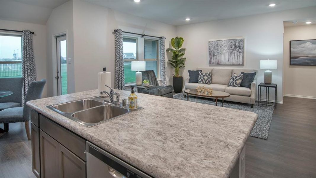 Kitchen with light countertops, open floor plan, dark wood-type flooring, dishwasher, and a center island with sink