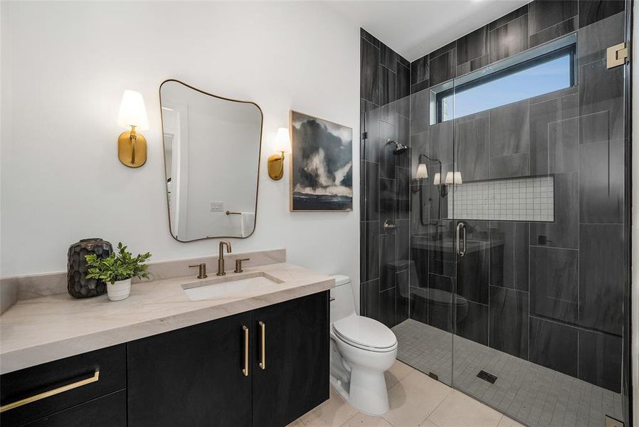 Full bath featuring vanity, a shower stall, and light tile patterned floors Full bath featuring vanity, a shower stall, and light tile patterned floors