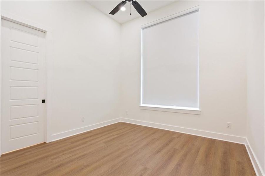 Unfurnished room featuring wood finished floors and a ceiling fan