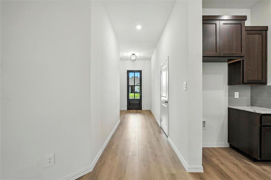 Hall with light wood-style flooring and recessed lighting