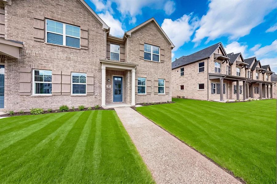 View of front of home featuring brick siding and a front yard