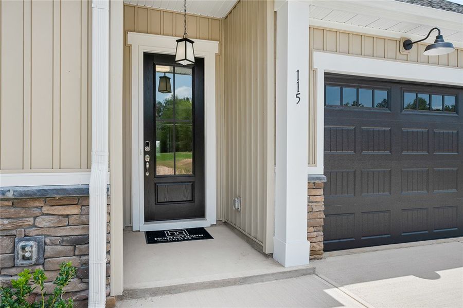 A welcoming entry featuring a black panel door wit A welcoming entry featuring a black panel door wit