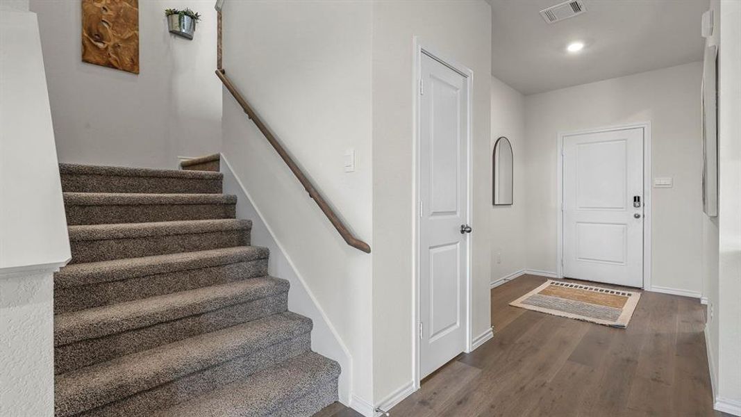 Stairway with wood finished floors and recessed lighting